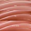 Glossy swatches showcase Lush Pout, ColourPop So Juicy Plumping Gloss Balm with Peptides: three nude-pink shades - Doe (rosy beige), PSL (warm caramel), and Vacay Mode (peachy nude) - layered in curved stripes on a clean backdrop.