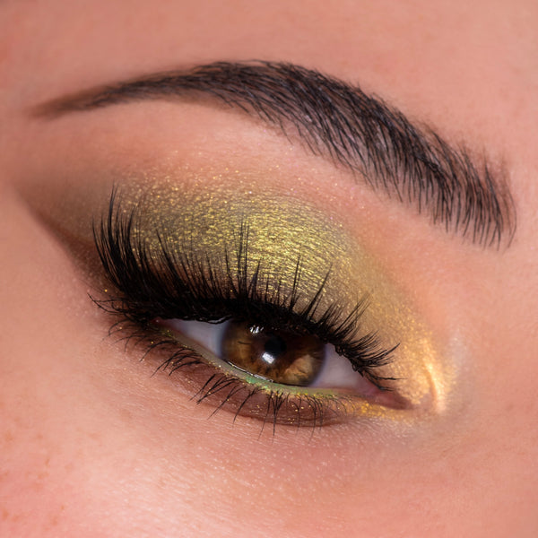 Sweet as Hunny ColourPop Eye & Lip Set eye look, featuring honey-gold metallic eyeshadow with a lime shimmer along the lower lash line, fluttery black lashes, and a bright inner-corner highlight in a close-up beauty swatch.