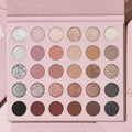 Major Eye Candy shadow palette & brush set by ColourPop, opened to 30 pans of mattes and glitter metallics in nudes, mauves, pinks, taupes, coppers, silver, charcoal, and black, displayed in a blush‑pink case on a pale pink background.