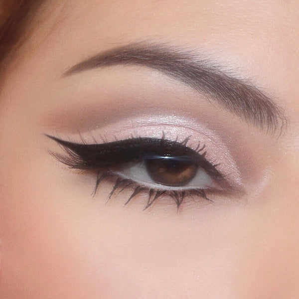 Close-up eye wears cool taupe shimmer and soft mauve crease from the Stone Cold Fox shadow palette, finished with a sharp black wing and defined lashes, showcasing a neutral glam look from the ColourPop Shadow Palette collection.