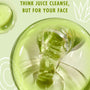 Avocado + Aloe Double Shot ColourPop Face Serum pouring in a glossy green stream from a clear bottle onto a reflective surface, on a pale green background with aloe doodles and the line Think juice cleanse, but for your face.