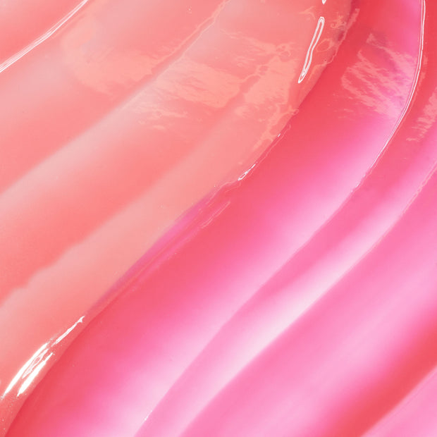 Glossy pink lip oil swatches flowing in wavy stripes, showcasing It’s Giving Juicy, the ColourPop So Juicy Lip Oil Set, with high-shine finish and gradient rosy shades on a smooth surface.