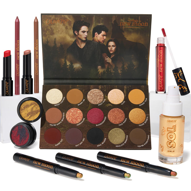 ColourPop Full Collection Set Twilight New Moon bundle showcases an open 15‑pan eyeshadow palette with forest cover art, two Super Shock shadows, three shadow sticks, lip pencils, lippie stix, red gloss, and SOL glow oil on a white backdrop.