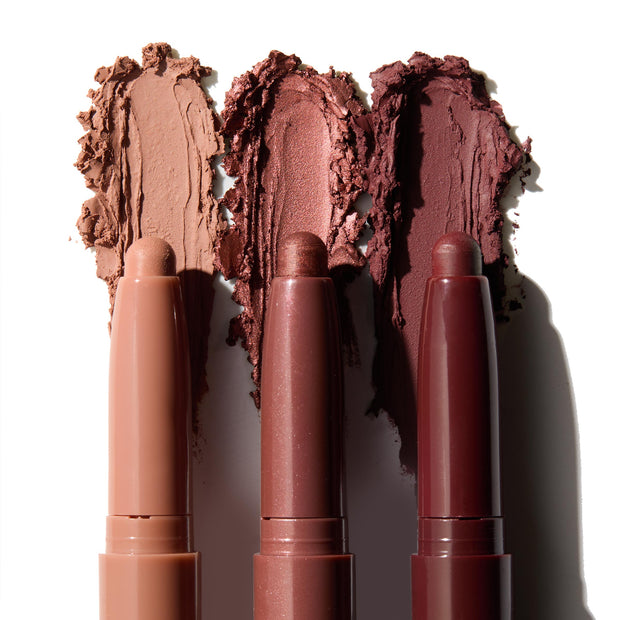 Three ColourPop Shadow Stix in Burgundy Besties lay side-by-side, each topped with a swipe of color - matte beige, metallic rose, and deep burgundy - demonstrating creamy, blendable payoff on a white background.