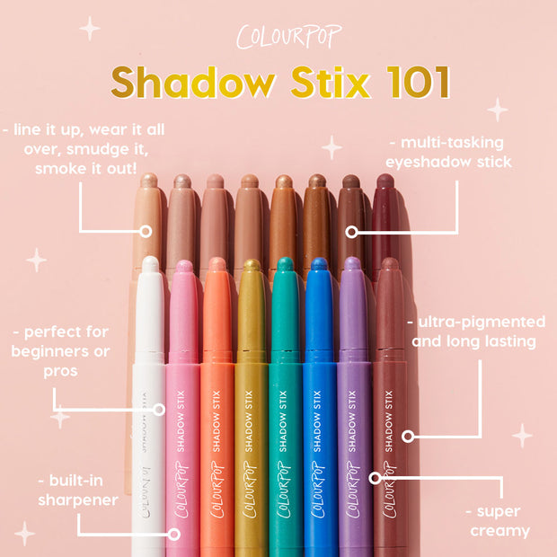 Surf Sesh Shadow Stix standing uncapped among a rainbow lineup of ColourPop Shadow Stix on a pink backdrop, showcasing creamy, ultra‑pigmented, long‑lasting, multi‑tasking eyeshadow with a built‑in sharpener - great for beginners or pros.