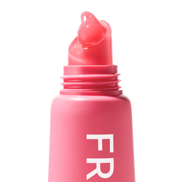Watermelon Sugar Fresh Kiss Glossy Balm swirls onto a slanted applicator tip, a dewy pink dollop atop a hot-pink tube with partial “FR” lettering; macro close-up on white, ColourPop Fresh Kiss Glossy Balm.