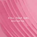 Still That Girl Ultra Glossy Lip Heart to Get swatch showing smooth, bright baby pink lip gloss spread in soft ridges across a solid pink background, highlighting its high-shine, creamy texture for bold, glossy lips.