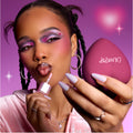 Model applies shimmery pink gloss while holding a heart-shaped senjyuan.onlinepact, showing bold purple and pink heart eye makeup that highlights the Heart to Get Full Collection full collection set against a dreamy pink background.