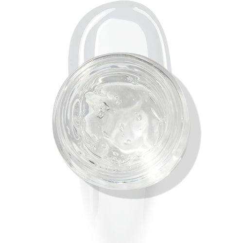 In The Clear Face & Eye Gloss in an open round jar gleams with a glossy swipe beneath it on a white background, showcasing the ColourPop Face & Eye Gloss for dewy, glass-skin shine on lids and cheeks.