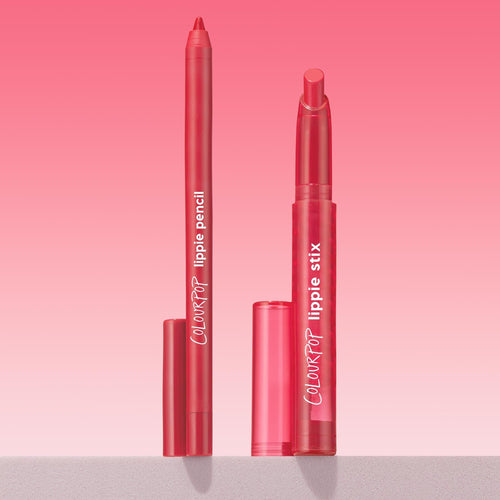 ColourPop Lippie Stix + Pencil Set in Va Va Voom shown uncapped, lippie pencil and matching Lippie Stix standing upright with translucent cherry-pink tubes and white logos, on a light surface against a pink gradient background.