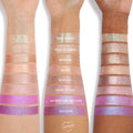 Field of Fairies Jelly Much Shadow swatched in parallel stripes on three forearms, showing a light pink iridescent shimmer alongside nude to lilac companions; creamy, long-wear payoff from the ColourPop Jelly Much Shadow collection.