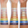 Emo Inside ColourPop Jelly Much Shadow swatched on three forearms - deep glittery violet at the bottom of each arm - shown with labeled shades Super Cool, Hallucinogenius, Big Ego, Shiny Penny, Brentwood, Billionaire, and Stargaze to compare shimmer payoff.