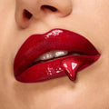 Glossy deep-red lips showcase high-shine lip gloss with a fang-shaped drip, spotlighting the Twilight New Moon x ColourPop Full Collection Set, a ColourPop Full Collection Set inspired by vampy glamour.