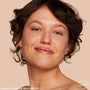 Model’s face wearing Medium 11 N, showing a fresh, dewy finish from the ColourPop Pretty Fresh Tinted Moisturizer; light coverage evens skin tone with a natural glow in a close-up against a soft beige backdrop.