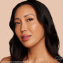 ColourPop Hyaluronic Hydrating Foundation in Medium 100 W delivering dewy, even medium coverage on a model’s face, showcasing smooth skin and a natural glow in a studio close-up against a soft beige background.