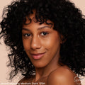 Model wearing ColourPop Pretty Fresh Creamy Concealer in Medium Dark 125 N (neutral undertone), showcasing smooth, natural coverage and a skin-like finish in a close-up against a soft beige background.