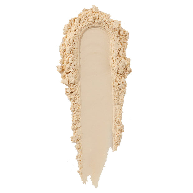 ColourPop No Filter Loose Setting Powder in Translucent forming a single curved swipe, finely milled with a soft beige tint and crumbly edges, showcasing a smooth matte texture against a clean white background.
