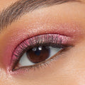 ColourPop Roy G. Biv Super Shock Shadow sweeps a metallic pink shimmer across a brown eye, showing smooth payoff and fine sparkle on the lid, with defined lashes and a clean brow in a close-up beauty swatch.