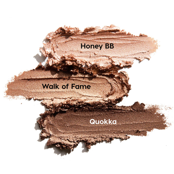 ColourPop Shadow Stix Shimmering Golds swatches display three creamy metallic strokes on a white background - Honey BB (champagne), Walk of Fame (warm gold), and Quokka (deep bronze) - smeared to showcase shimmer and blendable payoff.