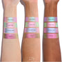 Colourpop Shadow Stix Game Over swatched on three skin tones, showing the shimmery pink-to-green duochrome strip labeled Game Over between Disco Disco and Cotton Candy shades on each forearm for comparison.