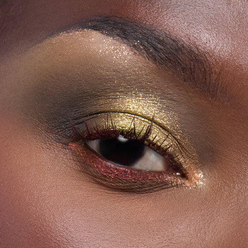 Shimmering chartreuse-gold lid with a smoky olive crease and red glitter along the lower lash line, created using the Beware Ogre Shadow Palette, a ColourPop Shadow Palette, highlighting bold metallic payoff in a close-up eye makeup look.