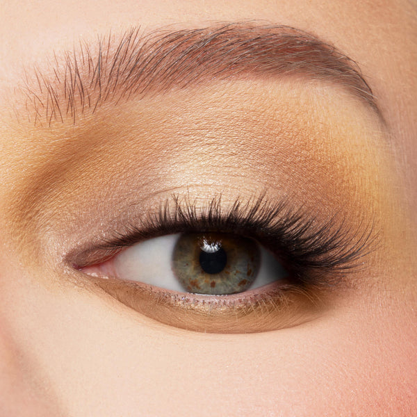 Close-up eye wears warm neutral glam: matte tan transition, champagne-gold shimmer on lid, soft brown in crease, and long lashes, showcasing The Toys Are Here Shadow Palette, a ColourPop Shadow Palette for everyday sunlit neutrals.