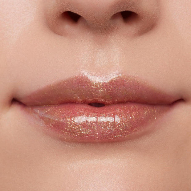 Glossed lips wearing ColourPop Ultra Glossy Lip in Pascal, a sheer clear gloss with gold micro-shimmer, reflecting studio light for a high-shine finish in a close-up beauty swatch.