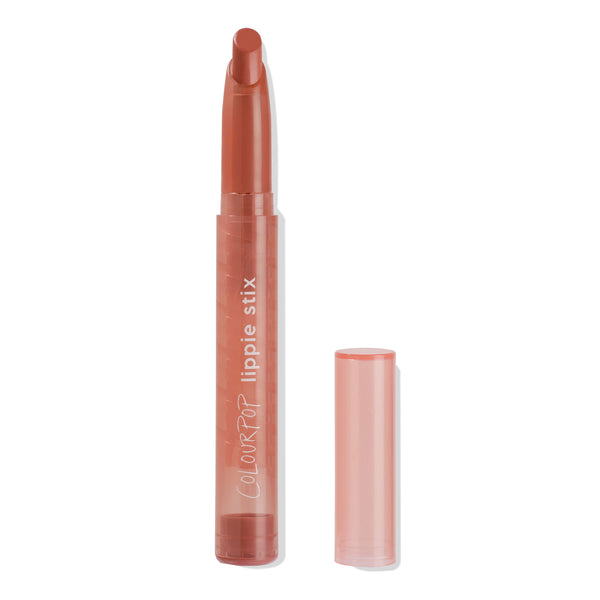 ColourPop Lippie Stix in At Twilight stands uncapped, revealing a slanted warm terracotta lipstick bullet, with a translucent peach tube and the matching cap set beside it on a clean white background.