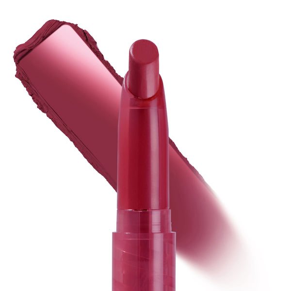ColourPop Lippie Stix Hot in Here shown upright, a slim twist-up lip crayon in deep berry-red with a bold matching swatch brushed diagonally behind it on a white background, highlighting pigment and shade detail.