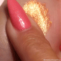 Brentwood ColourPop Jelly Much Shadow swatched on skin, a molten warm-gold gel eyeshadow being smoothed by a pink‑shimmer manicured fingertip, showcasing wet‑metallic sparkle and high‑pigment payoff in a close‑up hand swatch.